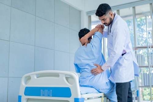 A doctor feeling a patient's lower back